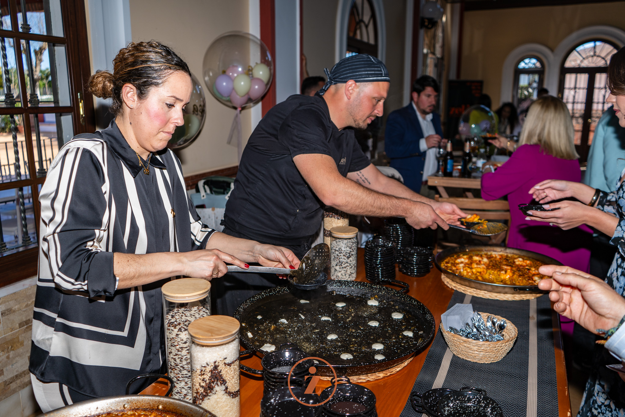 personas sirviendo arroz negro en una boda
